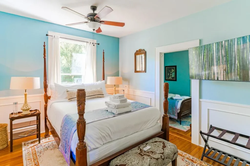 Bedroom with carved four-poster bed and wood floors at The Estate at Mount Dora