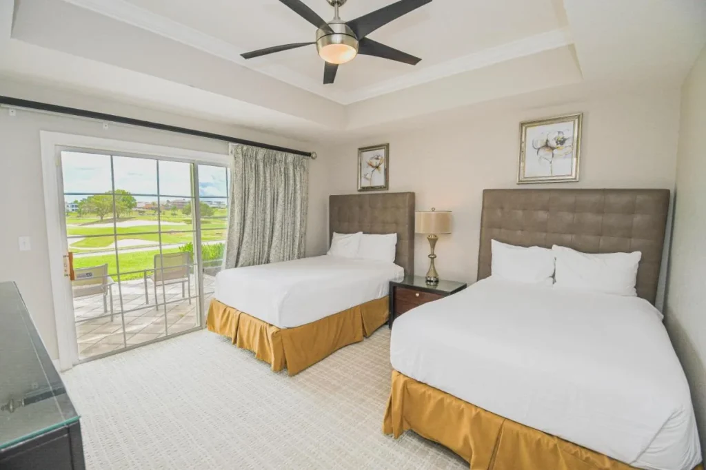 Bedroom with two beds and a patio door facing the golf course at Reunion Resort