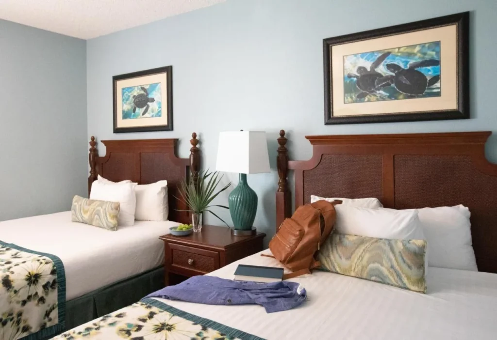 Bedroom with two beds, wooden headboards and sea turtle prints at Orange Lake Resort