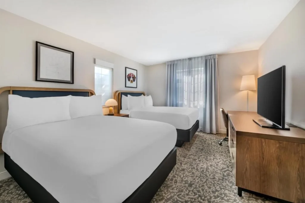 Habitaci&oacute;n con dos camas dobles, escritorio y TV en Sonesta ES Suites Lake Buena Vista