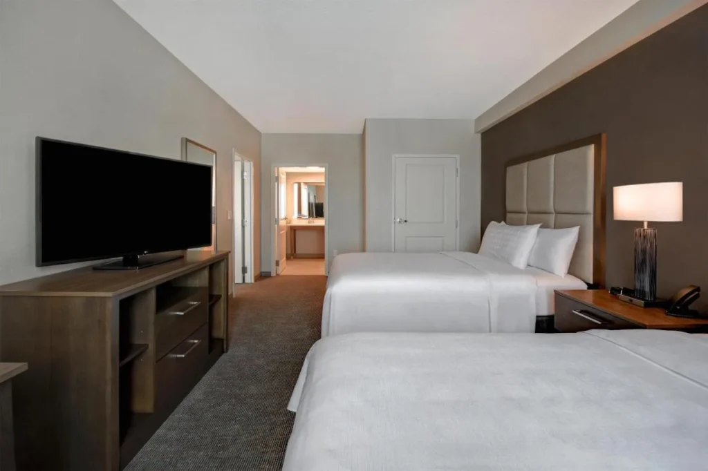 Bedroom with two queen beds and a TV at Homewood Suites Flamingo Crossings