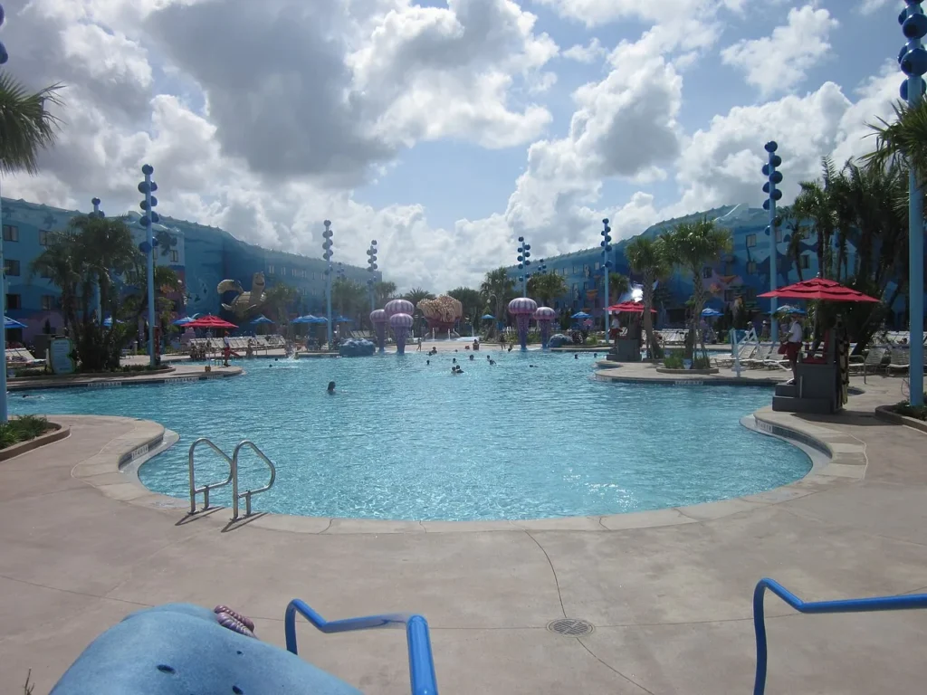 Big Blue Pool con postes en forma de medusas y sombrillas rojas en Disney's Art of Animation Resort