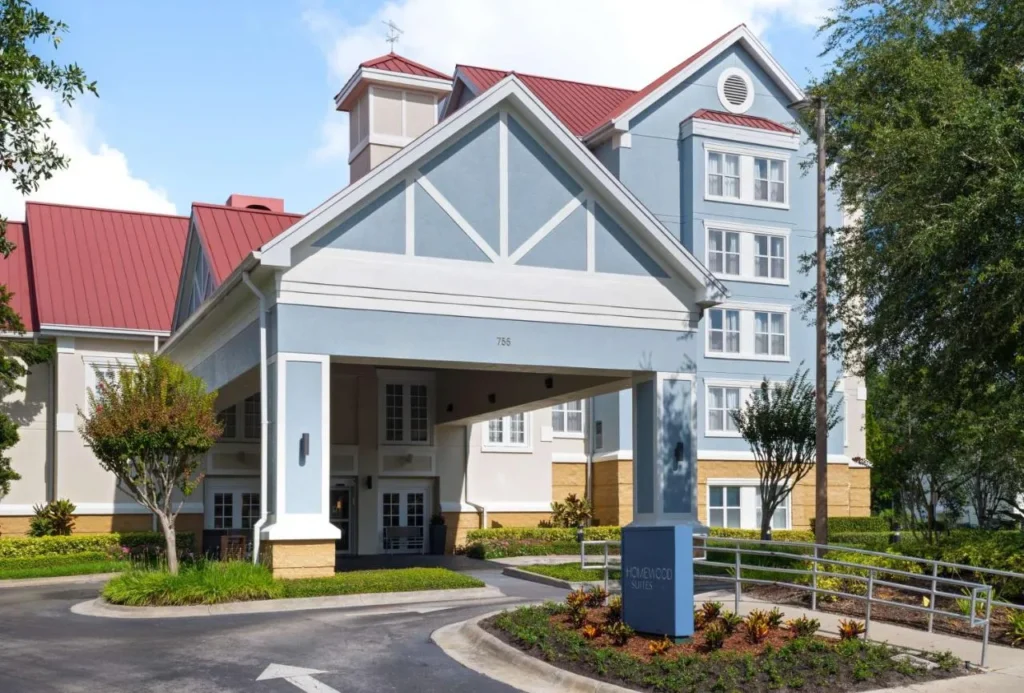 Dosel de entrada azul y blanco con techos rojos en Homewood Suites Lake Mary Orlando North