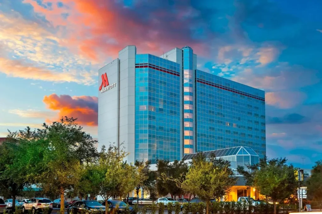 Torre de cristal azul del centro de Orlando Marriott en Creative Village bajo un cielo colorido de la puesta del sol