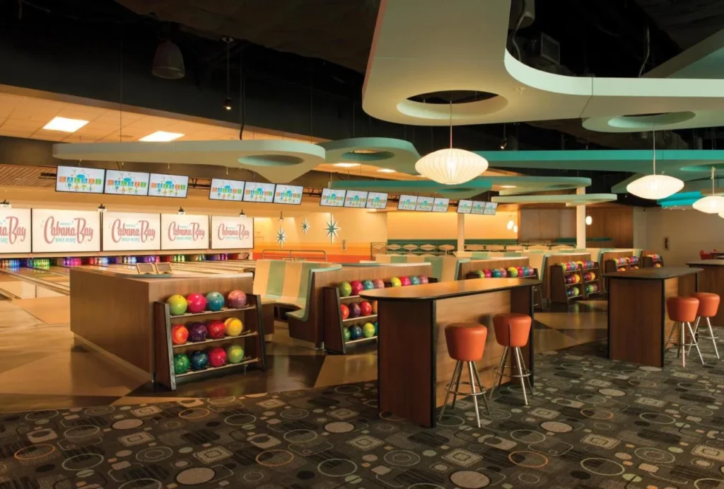 Bowling alley with retro lighting, ball racks and high tables at Universal's Cabana Bay Beach Resort
