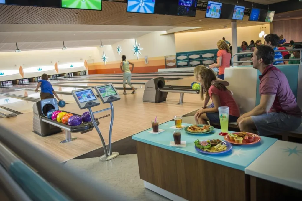 Calles de bolos con familias jugando y refrigerios en una mesa en Universal Cabana Bay Beach Resort