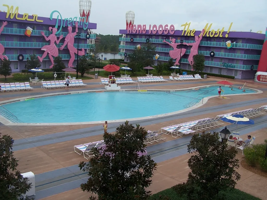 Bowling Pool con tumbonas a rayas entre los edificios de habitaciones púrpuras de la década de 1950 en Disney's Pop Century Resort