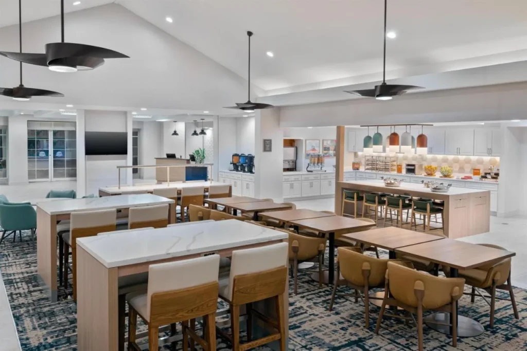 Breakfast area with communal tables and buffet counters at Homewood Suites Nearest to Universal Studios