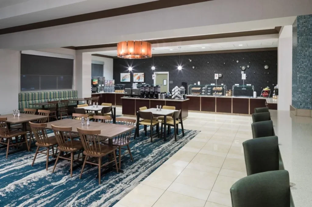 Zona de desayuno con mesas y buffet en el Fairfield Inn & Suites Orlando at SeaWorld