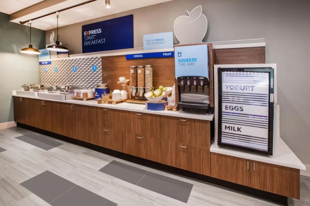 Breakfast bar with cereal dispensers and a drinks fridge at Holiday Inn Express Nearest Universal