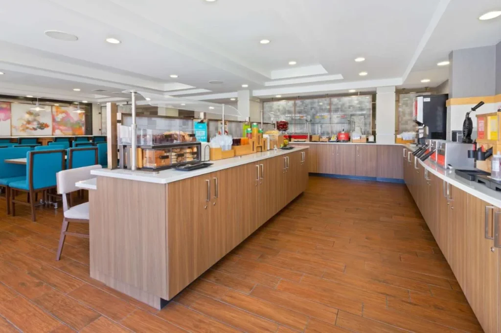 Breakfast buffet counters and blue dining chairs at Hampton Inn Orlando Near Universal Blv/International Dr