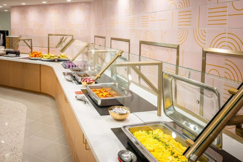 Desayuno buffet con huevos revueltos, papas y fruta fresca en Buena Vista Suites Orlando
