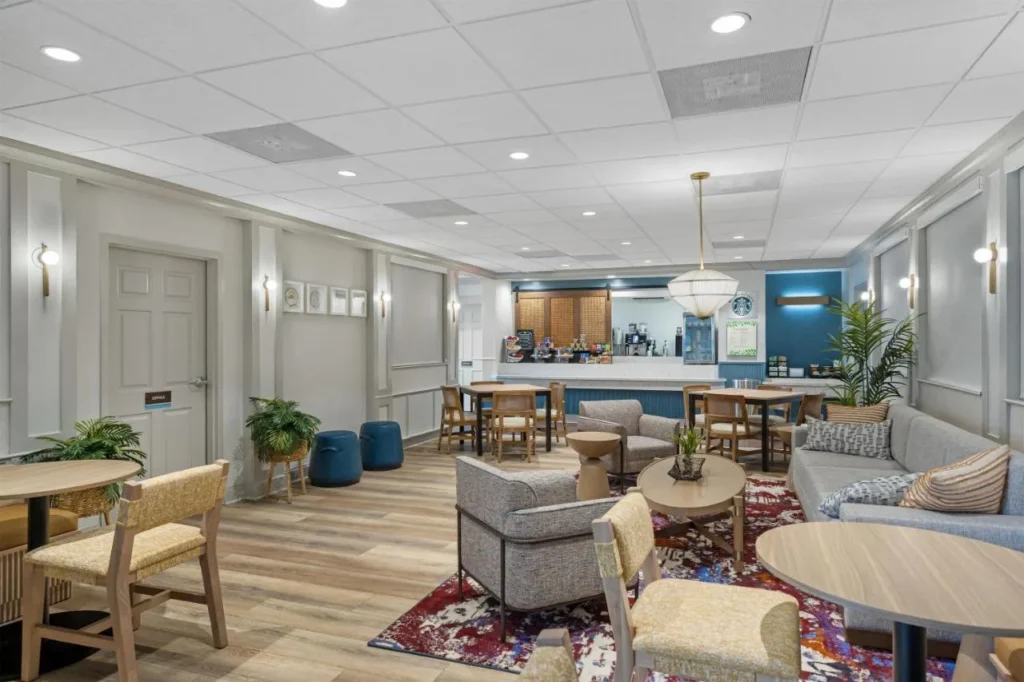Desayuno cafeter&iacute;a con sof&aacute;s y mesas en Sonesta ES Suites Lake Buena Vista