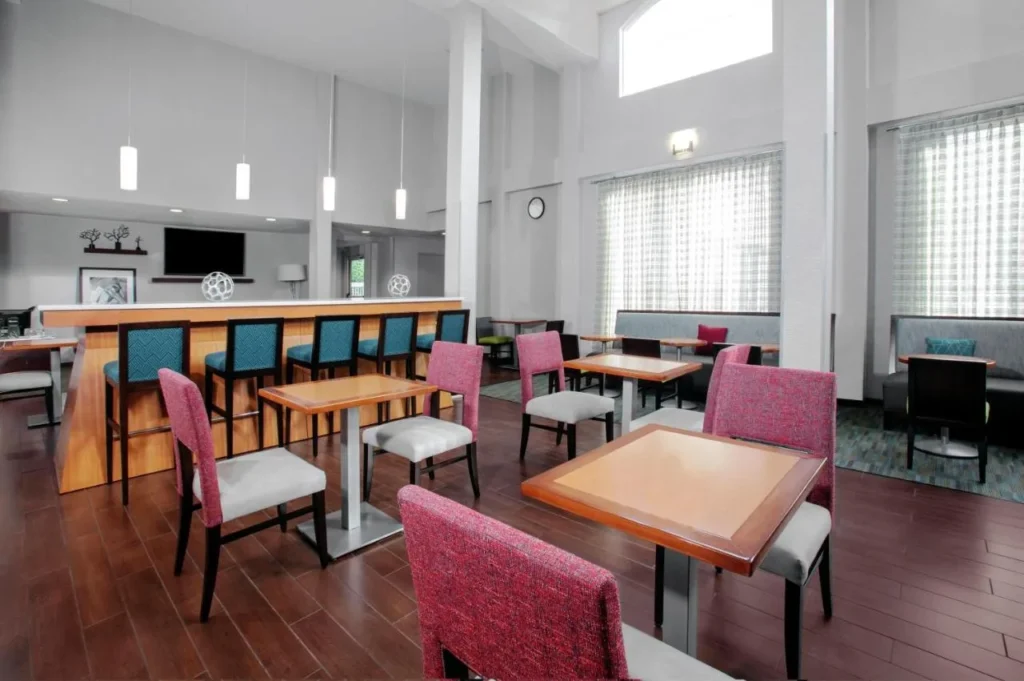 Breakfast room with bar stools and tables at Hampton Inn Orlando/Lake Buena Vista