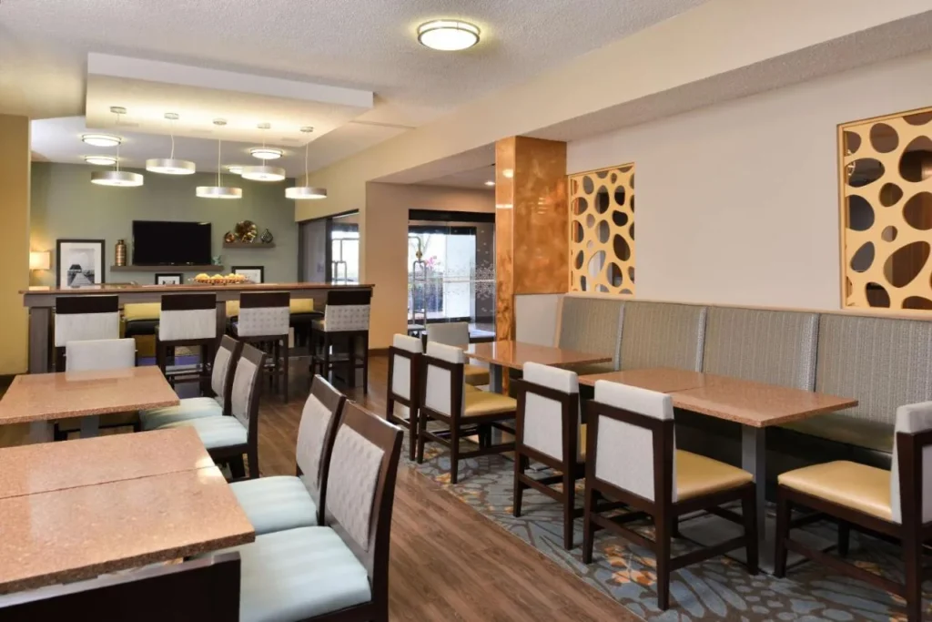 Breakfast room with booths, tables and pendant lights at Hampton Inn Closest to Universal Orlando