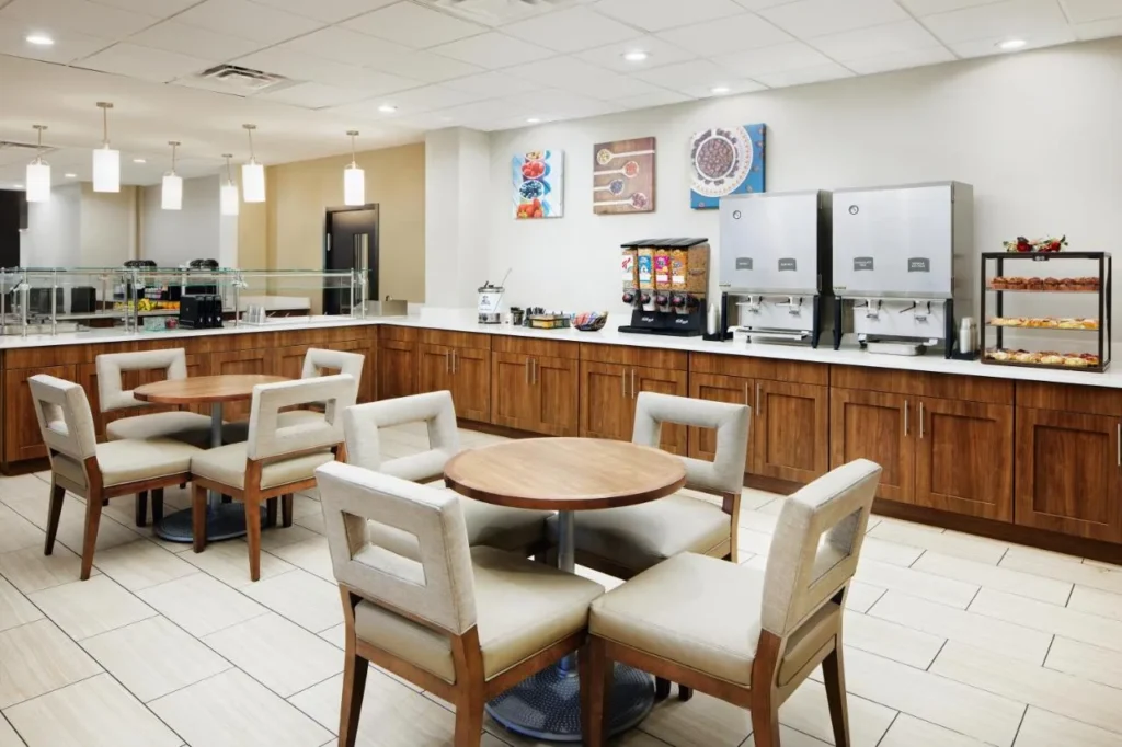 Breakfast room with round tables, cereal dispensers and pastries at Staybridge Suites Orlando Royale Parc Suites