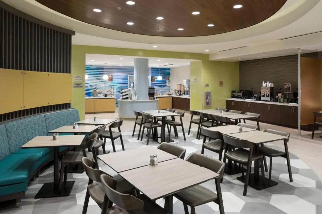 Breakfast room with teal banquettes, tables and buffet counters at SpringHill Suites Orlando at SeaWorld