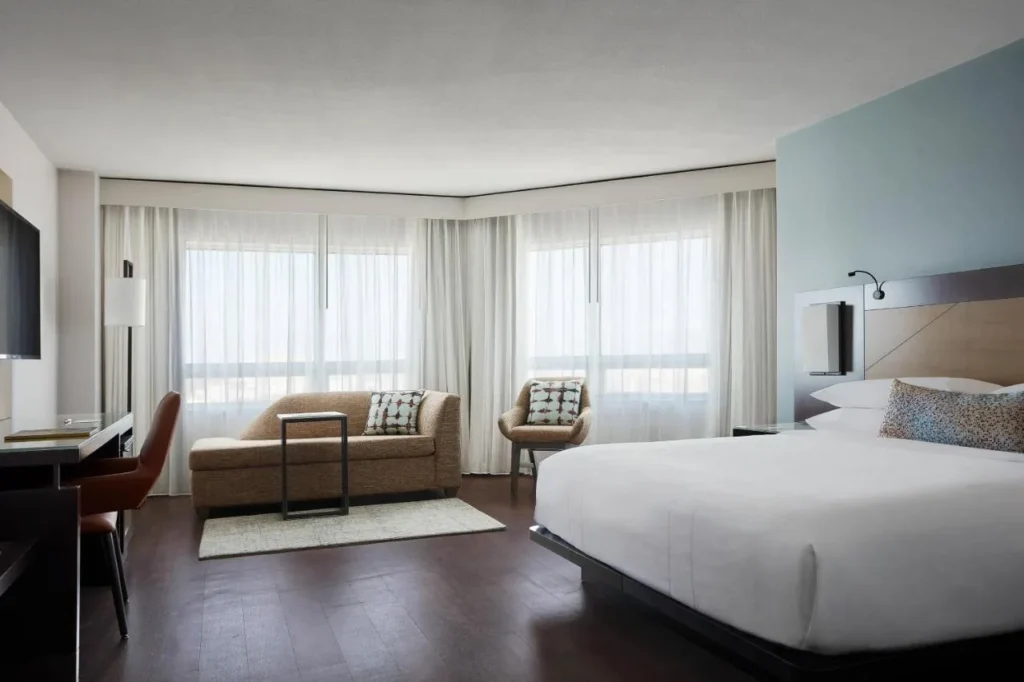 Luminosa habitaci&oacute;n king con sof&aacute; y amplios ventanales en el Marriott Orlando Downtown