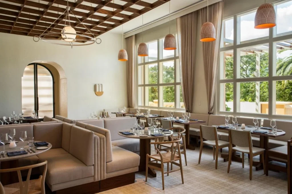 Luminoso restaurante comedor con cabinas, luces colgantes y ventanas altas en JW Marriott Orlando Grande Lakes