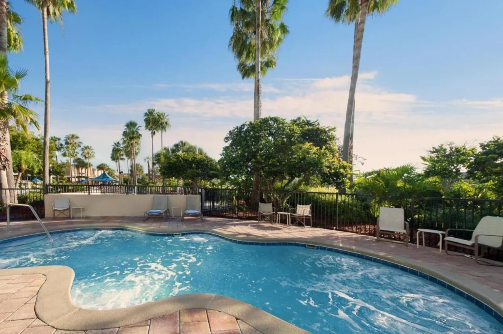 Bubbling hot tub on a fenced, palm-lined deck at DoubleTree at the Entrance to Universal