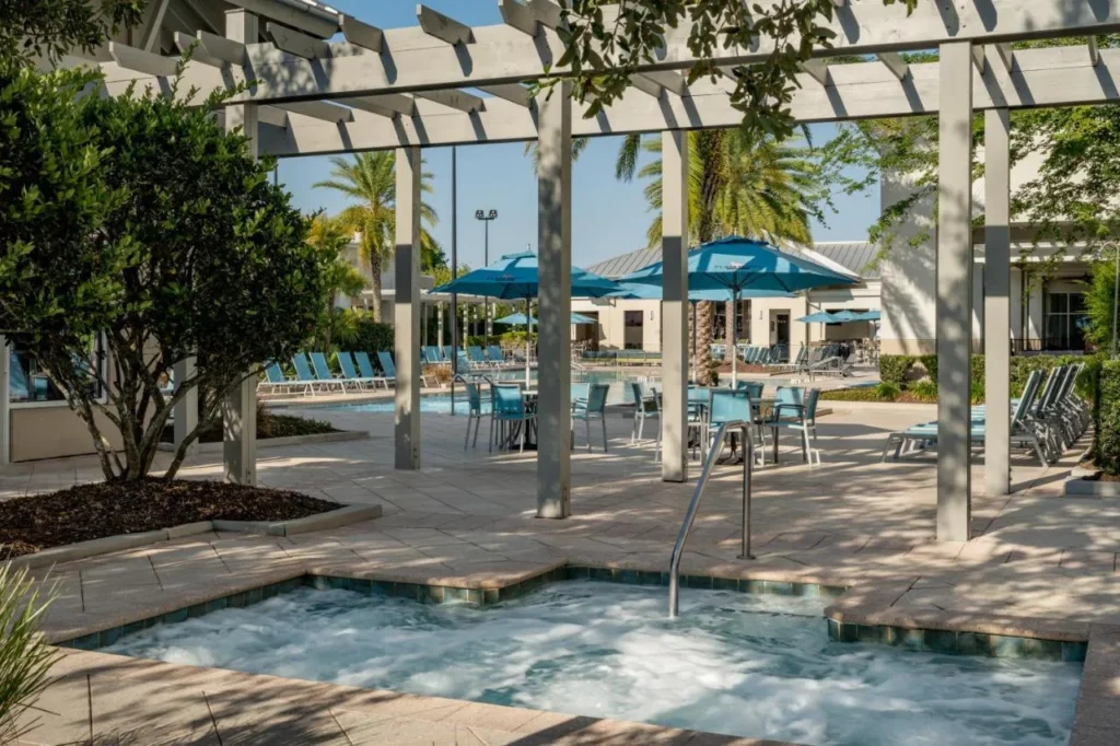 Burbujeante hidromasaje al aire libre bajo una pérgola junto a la piscina en SpringHill Suites Flamingo Crossings