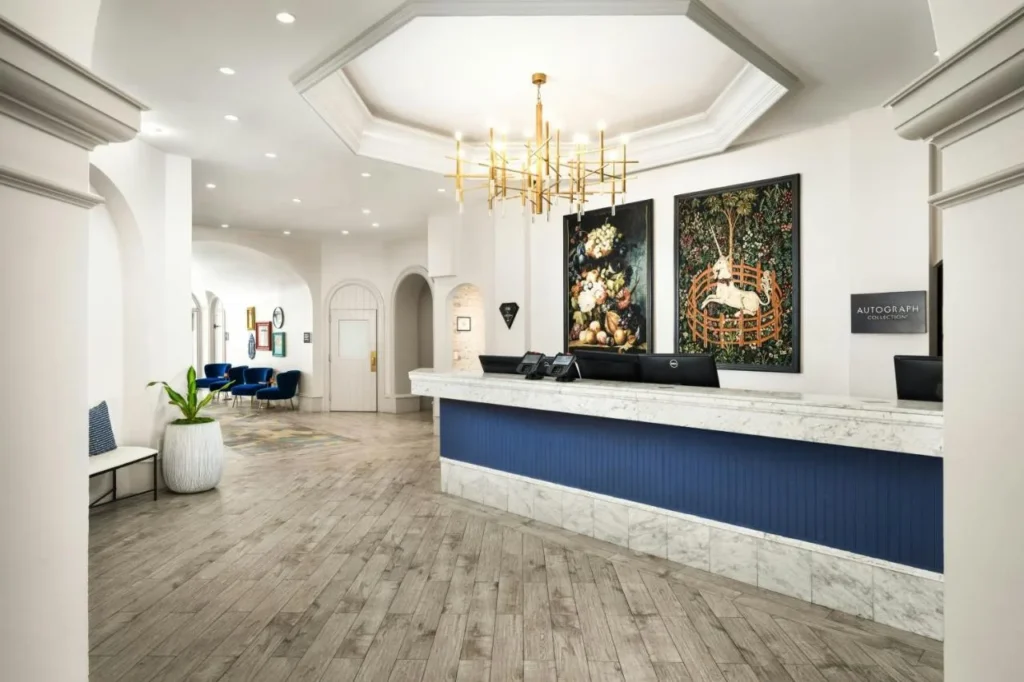 Castle Hotel lobby front desk with a unicorn tapestry, gold chandelier and blue counter