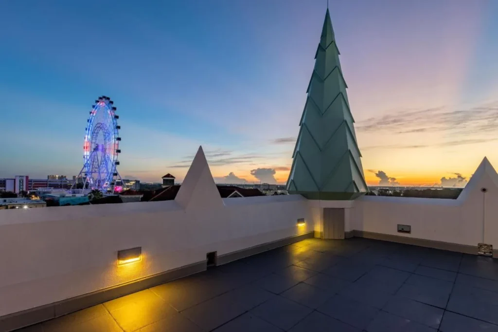 Castle Hotel Orlando rooftop terrace at sunset, with a green spire and The Wheel beyond