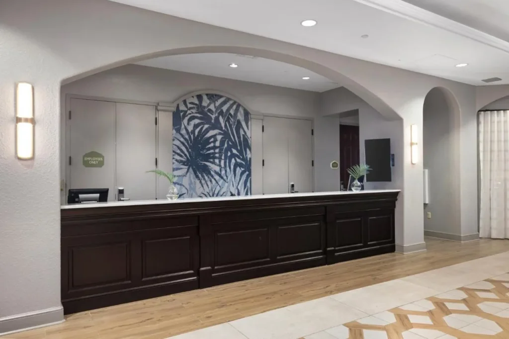 El mostrador de registro con un mural de hoja de palma azul detr&aacute;s de &eacute;l en Club Wyndham Bonnet Creek