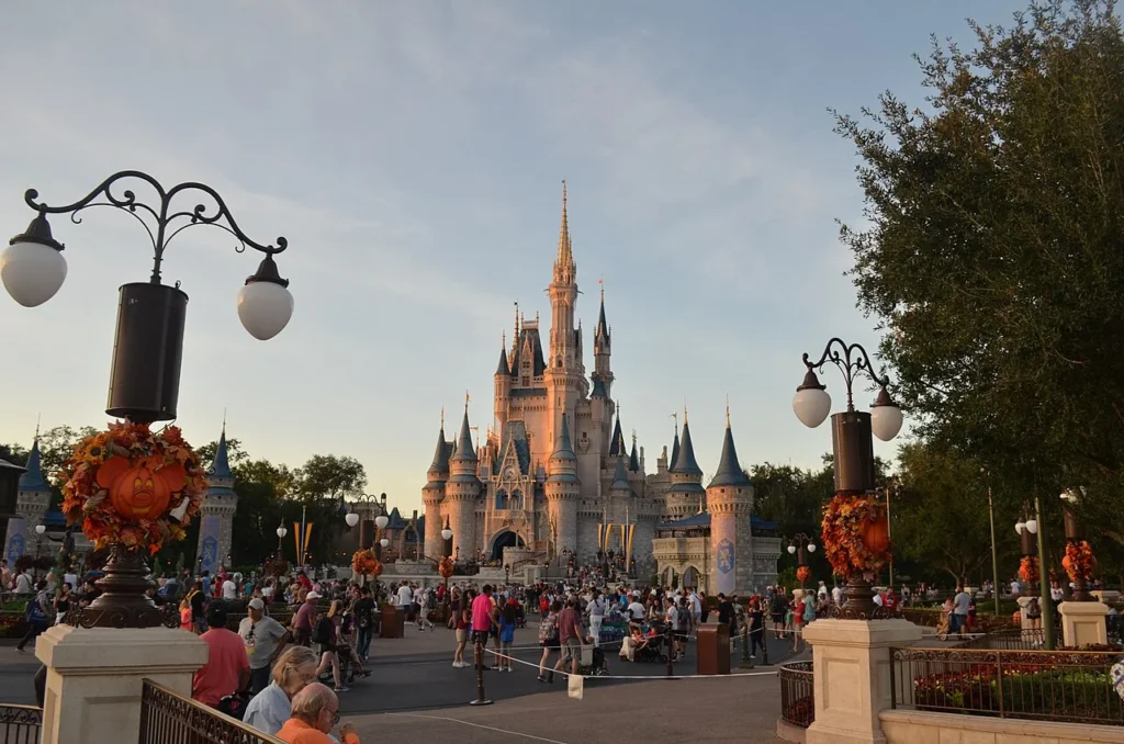 Cinderella Castle at sunset with pumpkin wreaths on hub lampposts, Magic Kingdom Halloween decorations