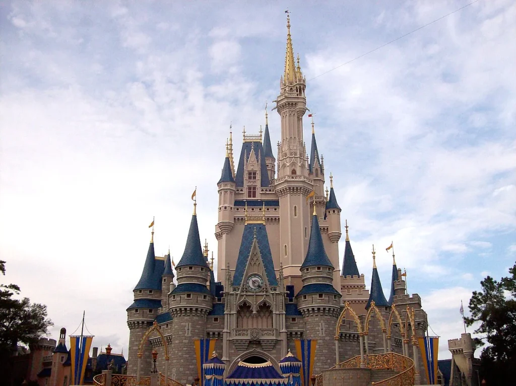 Cinderella Castle with blue spires and gold banners under a cloudy sky at Magic Kingdom