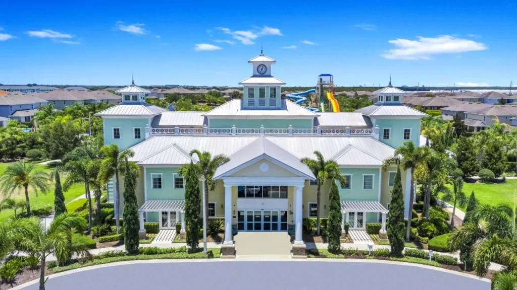 Clubhouse with a clock tower and water park slides behind at Encore Resort at Reunion