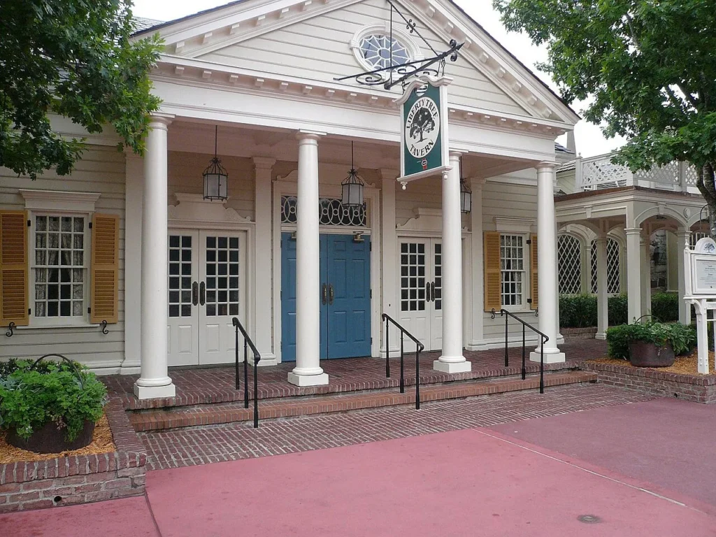 Colonial-style white facade and hanging sign of Liberty Tree Tavern in Magic Kingdom's Liberty Square