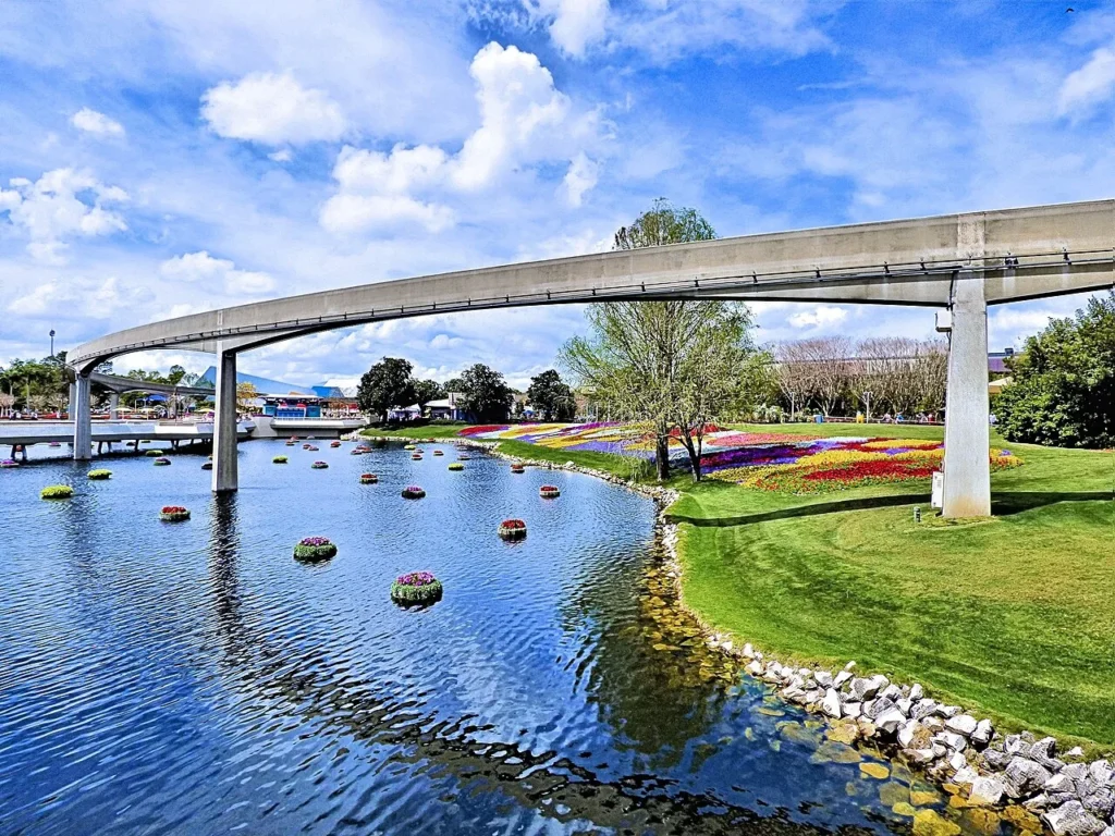 Coloridos macizos de flores junto a una laguna y la viga del monorraíl durante el Festival de Flores y Jardines de EPCOT