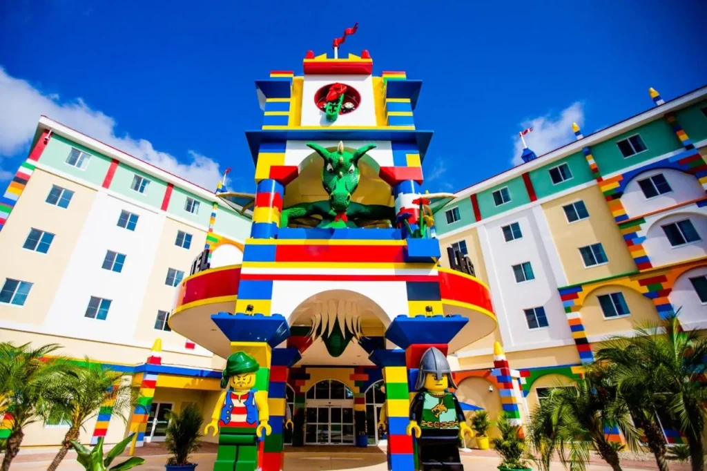 Colorful LEGOLAND Hotel entrance tower with a green dragon and minifigure statues at LEGOLAND Florida Resort