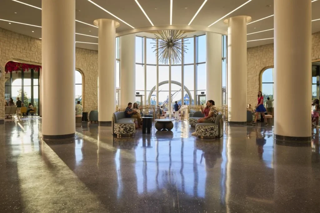 Vestíbulo de columnas con sofás redondos, pisos pulidos y ventanas de piso a techo en el Universal Helios Grand Hotel