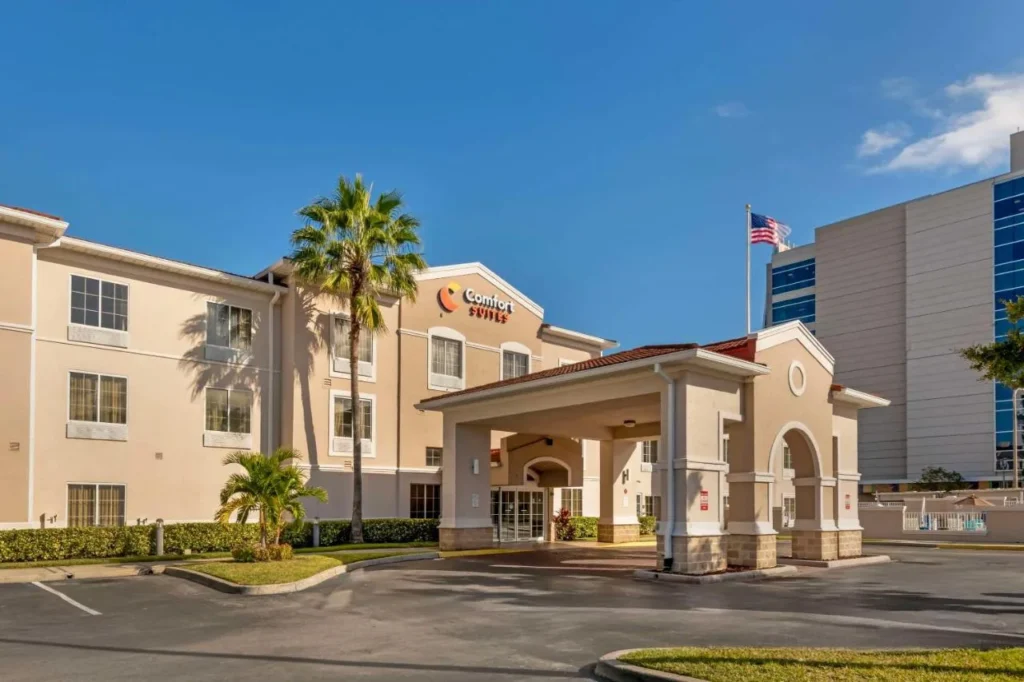 Comfort Suites Downtown Orlando entrance and covered drive-up with palm trees and blue sky