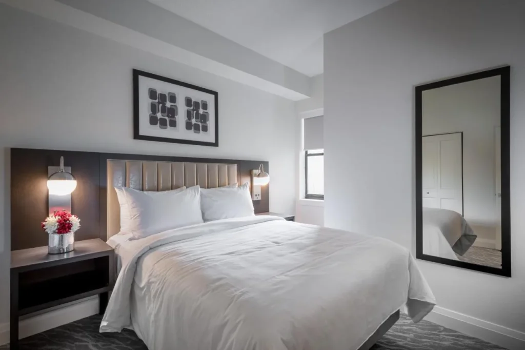 Dormitorio del condominio con una cama grande, lámparas de lectura y espejo alto en The Grove Resort