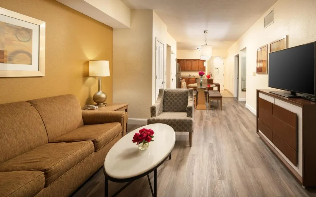 Condo sala de estar con sofá y TV que conduce a la zona de comedor en Floridays Resort Orlando