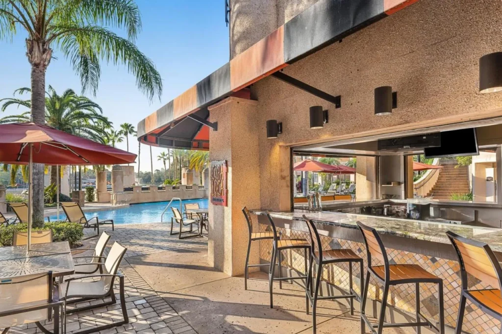 Barra junto a la piscina Copa Loca con taburetes de bar y mesas de sombrilla en Marriott's Grande Vista