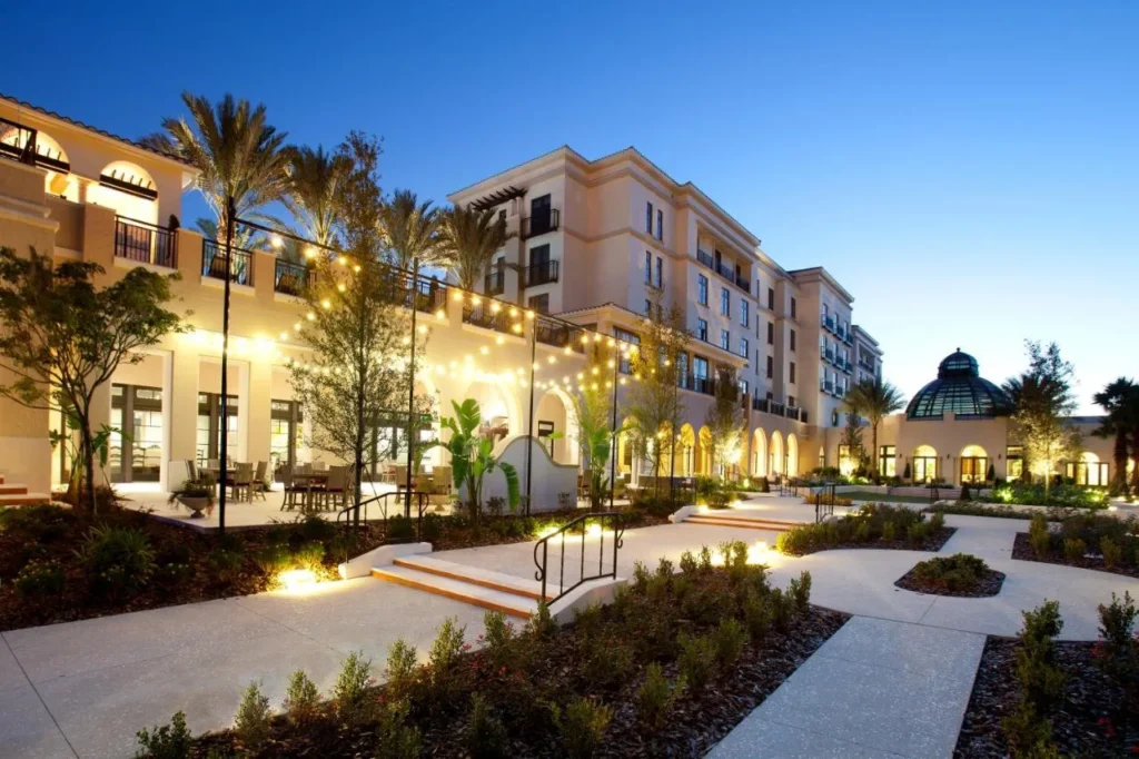 Jardines del Courtyard y luces de cadena al atardecer con una c&uacute;pula de cristal en el Alfond Inn