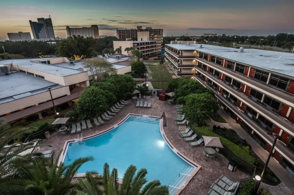 Courtyard pool, loungers and guest wings at dusk at Rosen Inn at Pointe Orlando
