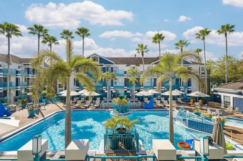 Courtyard piscina con palmeras, tumbonas y sombrillas en Sonesta ES Suites Lake Buena Vista