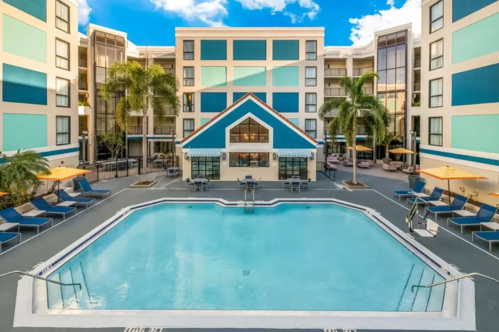 Courtyard swimming pool with blue loungers and yellow umbrellas at Sonesta ES Suites International Drive