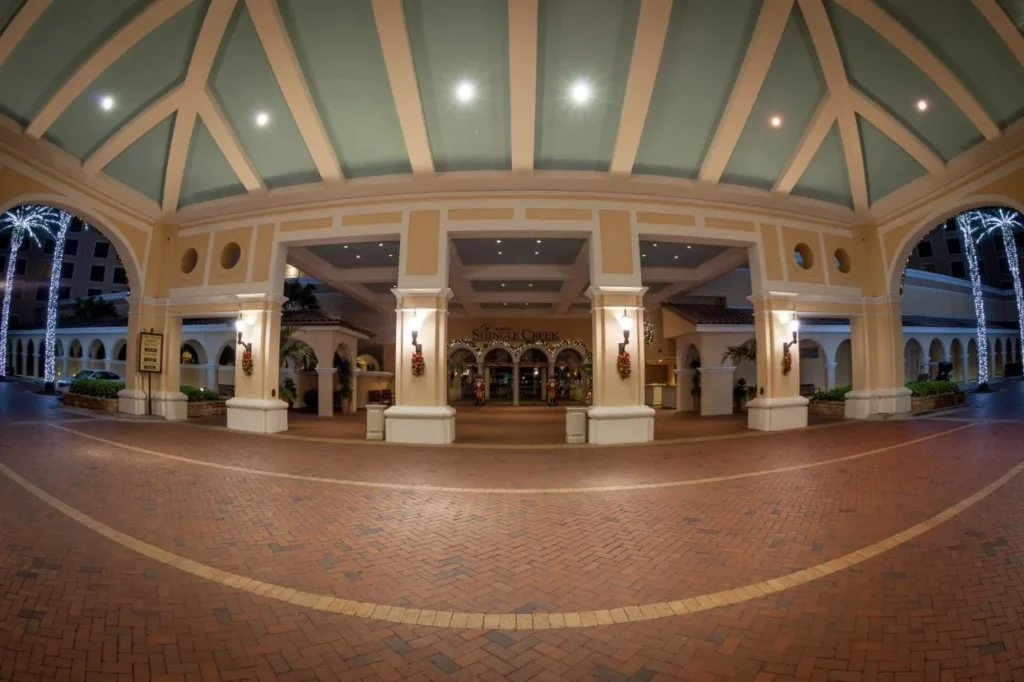 Corte de llegada cubierta en Rosen Shingle Creek iluminada por la noche con guirnaldas navide&ntilde;as y palmas envueltas en luz