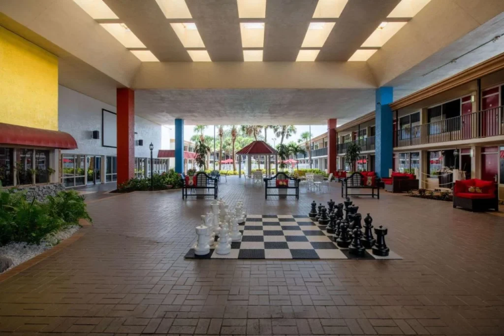 Courtyard cubierto con un juego de ajedrez gigante y asientos en Ramada by Wyndham Kissimmee Gateway
