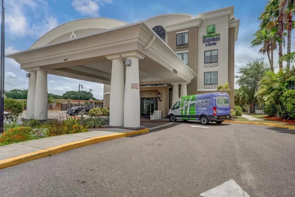 Entrada cubierta con una furgoneta de hotel de marca en Holiday Inn Express & Suites Tampa-USF-Busch Gardens