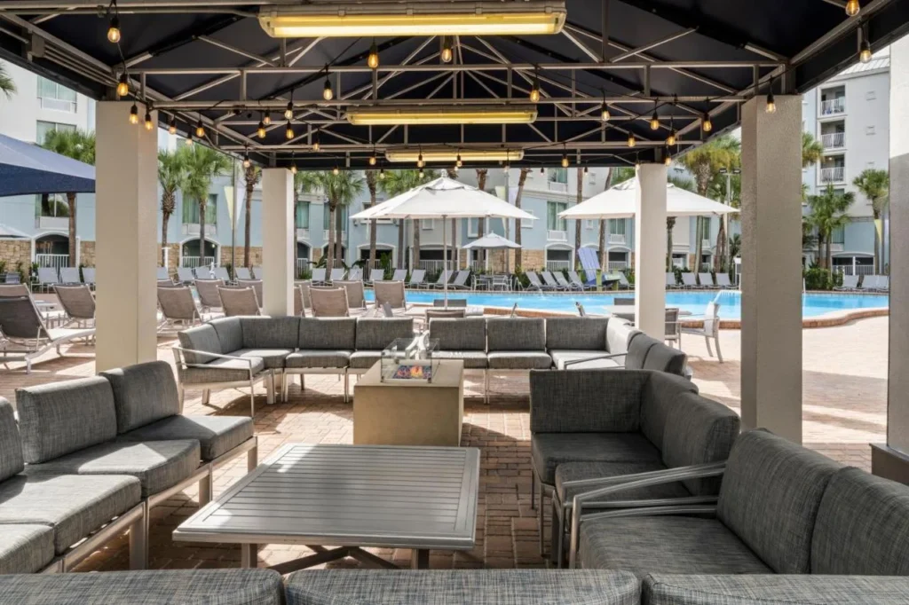 Covered lounge with fire table beside the pool at Holiday Inn Resort Orlando Lake Buena Vista