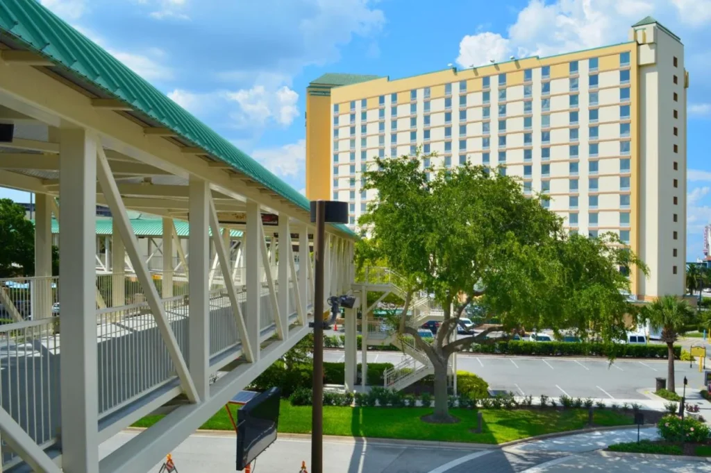 Covered pedestrian skybridge beside the Rosen Plaza Hotel tower on a sunny day
