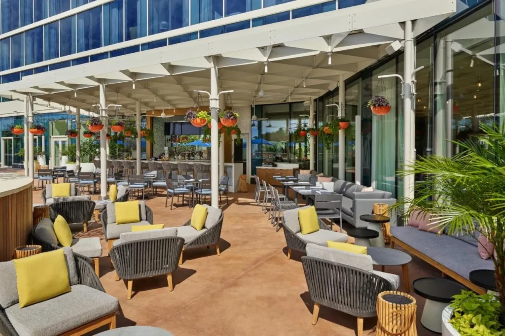 Covered terrace with lounge seating and a bar at Walt Disney World Swan Reserve