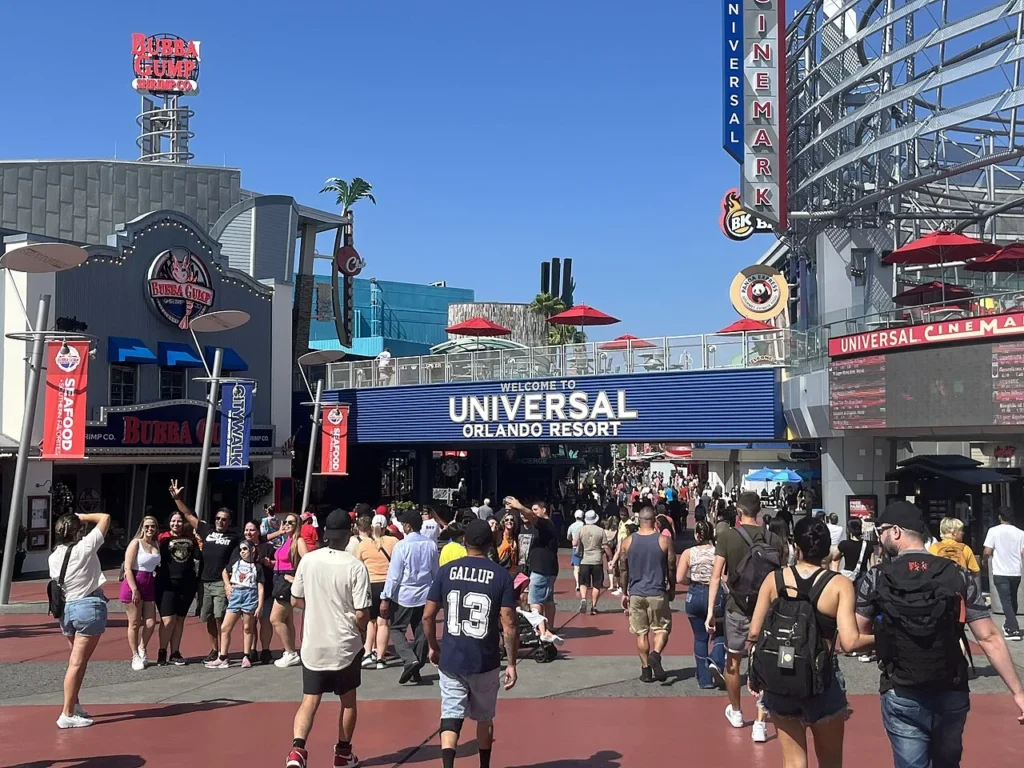 Crowds walking under the Welcome to Universal Orlando Resort sign at Universal CityWalk